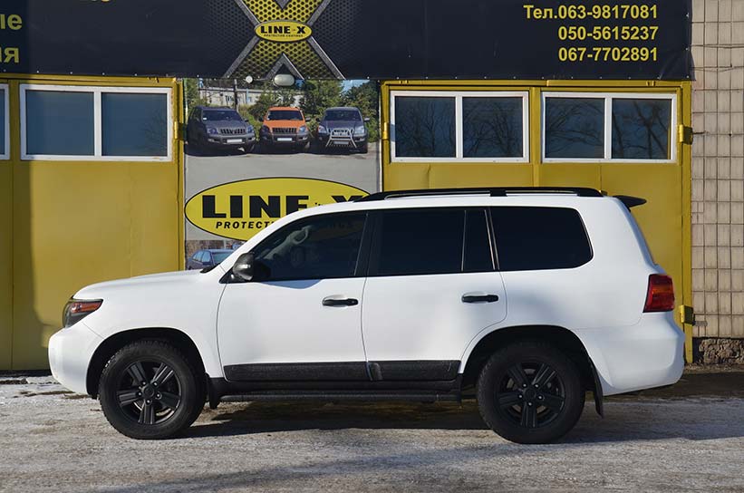 Защита кузова Toyota Land Cruiser полимерным покрытием Line-X черно-белого цвета