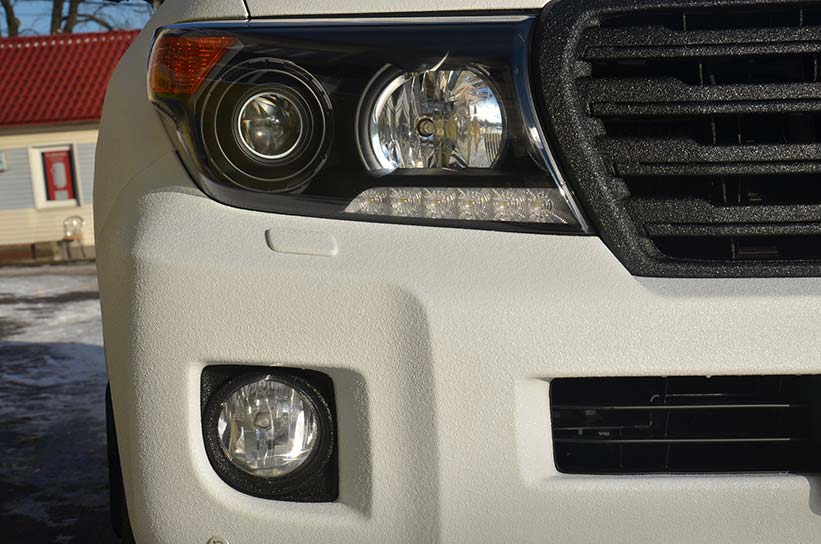 Защита кузова Toyota Land Cruiser полимерным покрытием Line-X черно-белого цвета